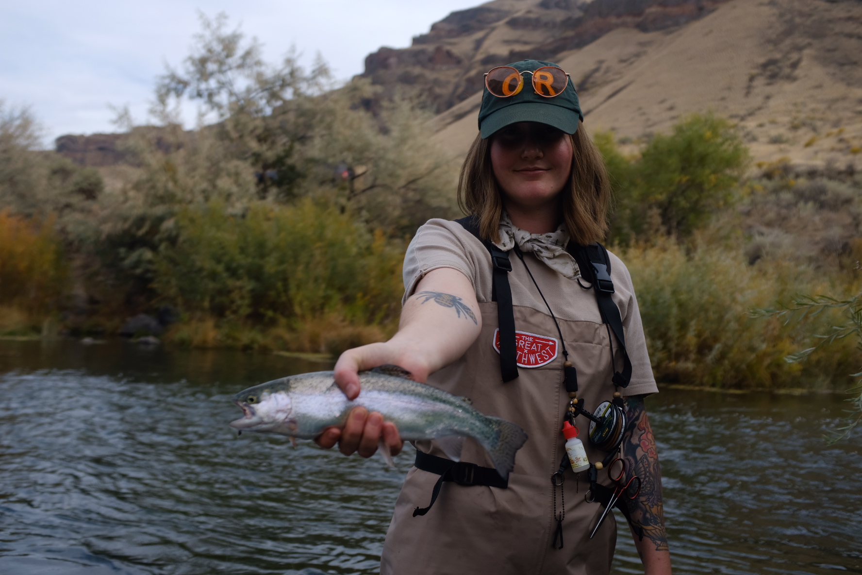 Woman standing in river holding a fish